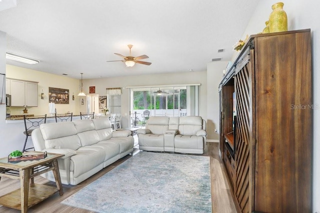 living area featuring ceiling fan, wood finished floors, and baseboards