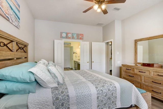 bedroom with connected bathroom, a ceiling fan, and wood finished floors
