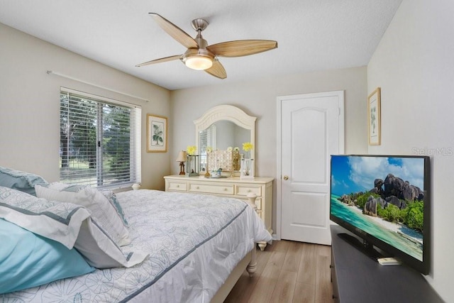 bedroom with light wood-style floors and a ceiling fan