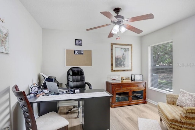 office space with light wood-style flooring, baseboards, and ceiling fan