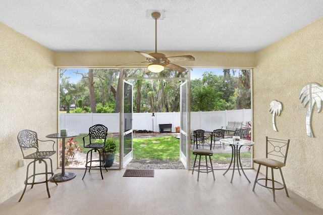 sunroom / solarium with ceiling fan, healthy amount of natural light, and outdoor dining space