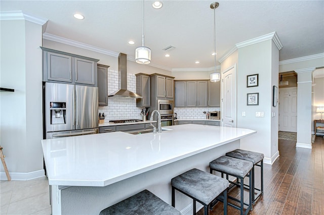 5728 Watercolor Dr, Lithia, FL 33547 - kitchen with stainless steel appliances, wall chimney exhaust hood, a sink, a breakfast bar, and baseboards