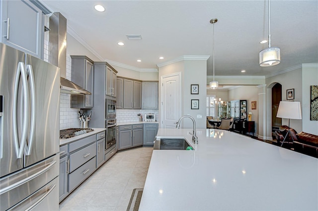 5728 Watercolor Dr, Lithia, FL 33547 - kitchen with stainless steel appliances, gray cabinetry, wall chimney exhaust hood, a sink, and backsplash