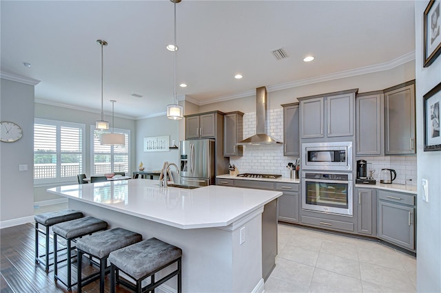 5728 Watercolor Dr, Lithia, FL 33547 - kitchen with appliances with stainless steel finishes, wall chimney exhaust hood, gray cabinetry, tasteful backsplash, and recessed lighting