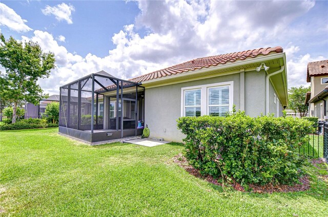 5728 Watercolor Dr, Lithia, FL 33547 - rear view of house with stucco siding, a lawn, and a tiled roof