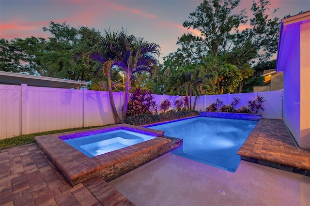 1436 30th Ave N, Saint Petersburg, FL 33704 - pool at dusk with an in-ground hot tub, a patio area, and a fenced backyard