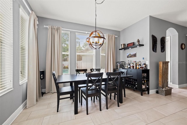 1436 30th Ave N, Saint Petersburg, FL 33704 - dining room with a chandelier, arched walkways, baseboards, and a bar