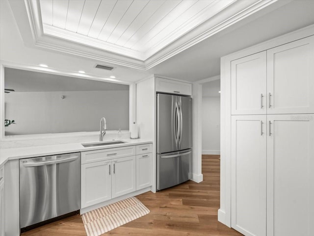 5700 Escondida Blvd S Unit 401, Saint Petersburg, FL 33715 - kitchen with appliances with stainless steel finishes, a sink, white cabinets, light countertops, and wood finished floors