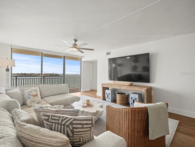 5700 Escondida Blvd S Unit 401, Saint Petersburg, FL 33715 - living area featuring a ceiling fan, baseboards, wood finished floors, and floor to ceiling windows