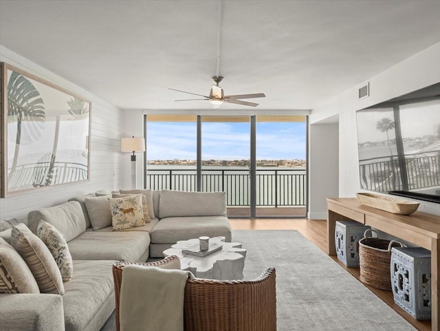 5700 Escondida Blvd S Unit 401, Saint Petersburg, FL 33715 - living area featuring a water view, ceiling fan, wood finished floors, and a wall of windows
