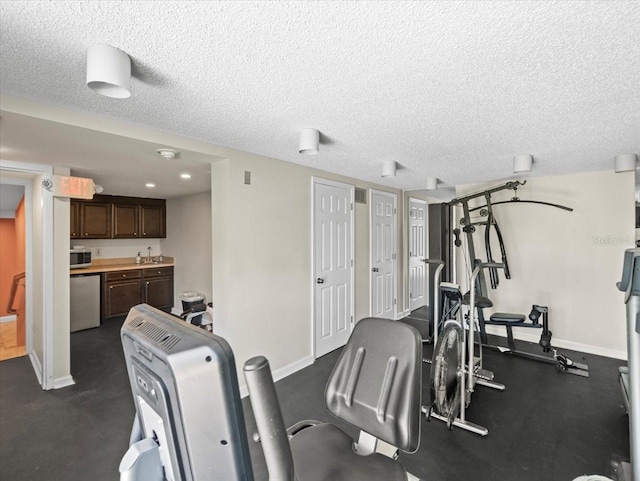 5700 Escondida Blvd S Unit 401, Saint Petersburg, FL 33715 - exercise room featuring baseboards, a textured ceiling, and bar with sink