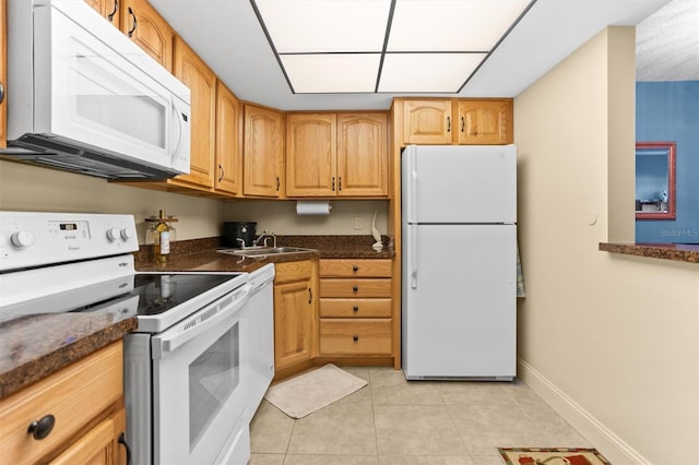4900 Brittany Dr S Unit 209, Saint Petersburg, FL 33715 - kitchen with white appliances, light tile patterned floors, a sink, baseboards, and dark countertops