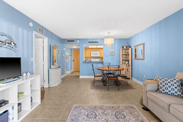 4900 Brittany Dr S Unit 209, Saint Petersburg, FL 33715 - living area featuring light tile patterned flooring, a chandelier, and baseboards