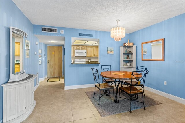 4900 Brittany Dr S Unit 209, Saint Petersburg, FL 33715 - dining space with a chandelier, light tile patterned floors, a textured ceiling, and baseboards