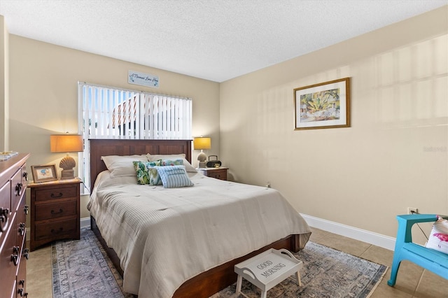 4900 Brittany Dr S Unit 209, Saint Petersburg, FL 33715 - bedroom featuring a textured ceiling, tile patterned flooring, and baseboards