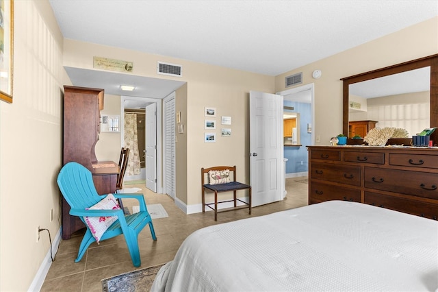 4900 Brittany Dr S Unit 209, Saint Petersburg, FL 33715 - bedroom with light tile patterned floors, baseboards, a closet, and ensuite bathroom