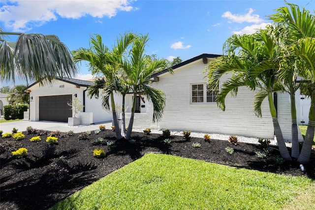 4618 Bayshore Blvd NE, Saint Petersburg, FL 33703 - view of side of home with a garage, concrete driveway, a lawn, and brick siding