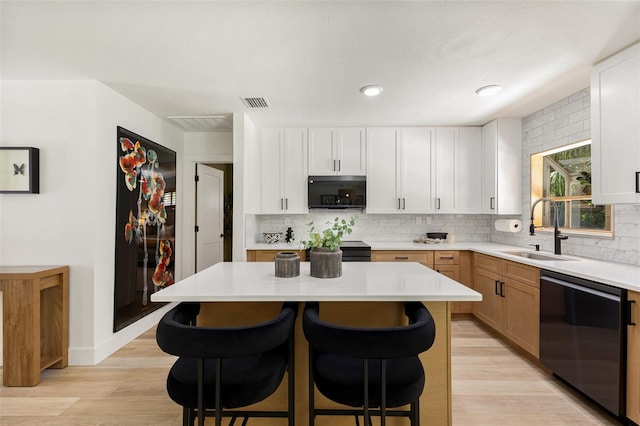 4618 Bayshore Blvd NE, Saint Petersburg, FL 33703 - kitchen with stainless steel dishwasher, a sink, a breakfast bar area, light countertops, and backsplash