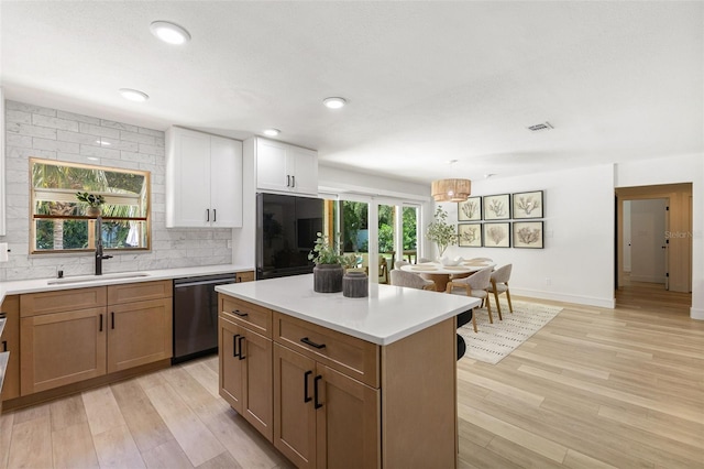 4618 Bayshore Blvd NE, Saint Petersburg, FL 33703 - kitchen with dishwashing machine, a sink, tasteful backsplash, light countertops, and light wood-type flooring