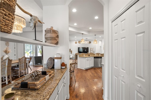 kitchen with stainless steel dishwasher, wood-type flooring, recessed lighting, white cabinets, and light stone countertops