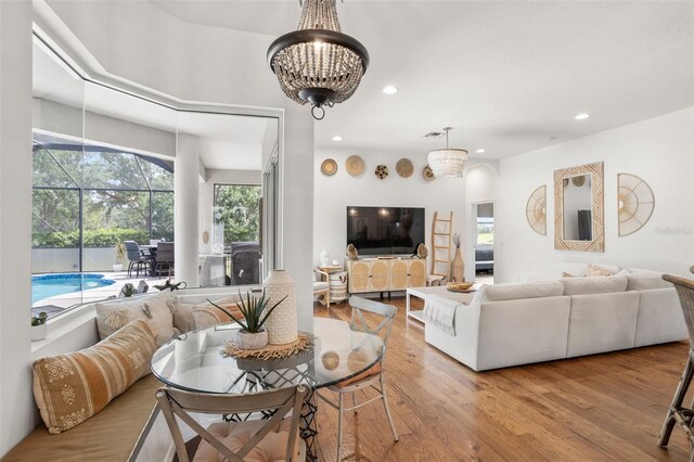 living room with wood finished floors, a chandelier, healthy amount of natural light, and recessed lighting