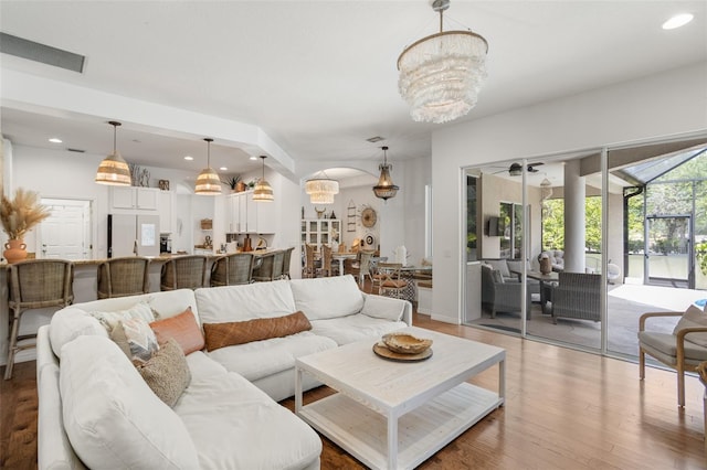 living room featuring a chandelier, light wood finished floors, and recessed lighting