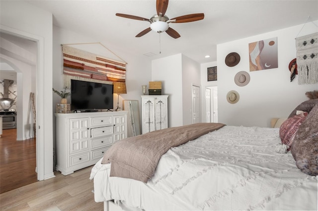 bedroom featuring light wood-type flooring, arched walkways, recessed lighting, and ceiling fan