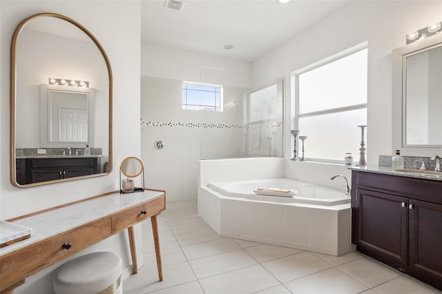 bathroom featuring a bath, tile patterned flooring, a walk in shower, and two vanities
