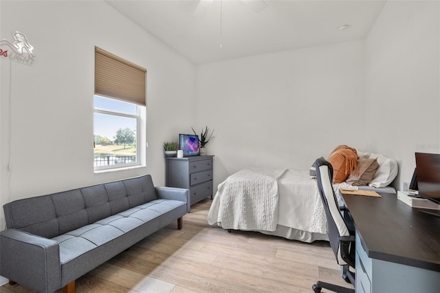 bedroom featuring light wood-type flooring, an office area, and a ceiling fan