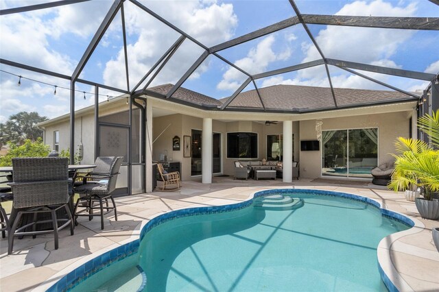 swimming pool featuring an outdoor hangout area, a patio, a ceiling fan, and glass enclosure