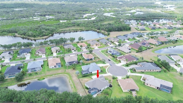 aerial view of property and surrounding area with a large body of water and nearby suburban area