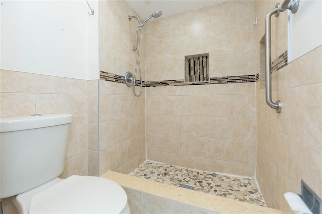 2211 Bay Berry Ln, Clearwater, FL 33763 - bathroom featuring toilet, tiled shower, and tile walls
