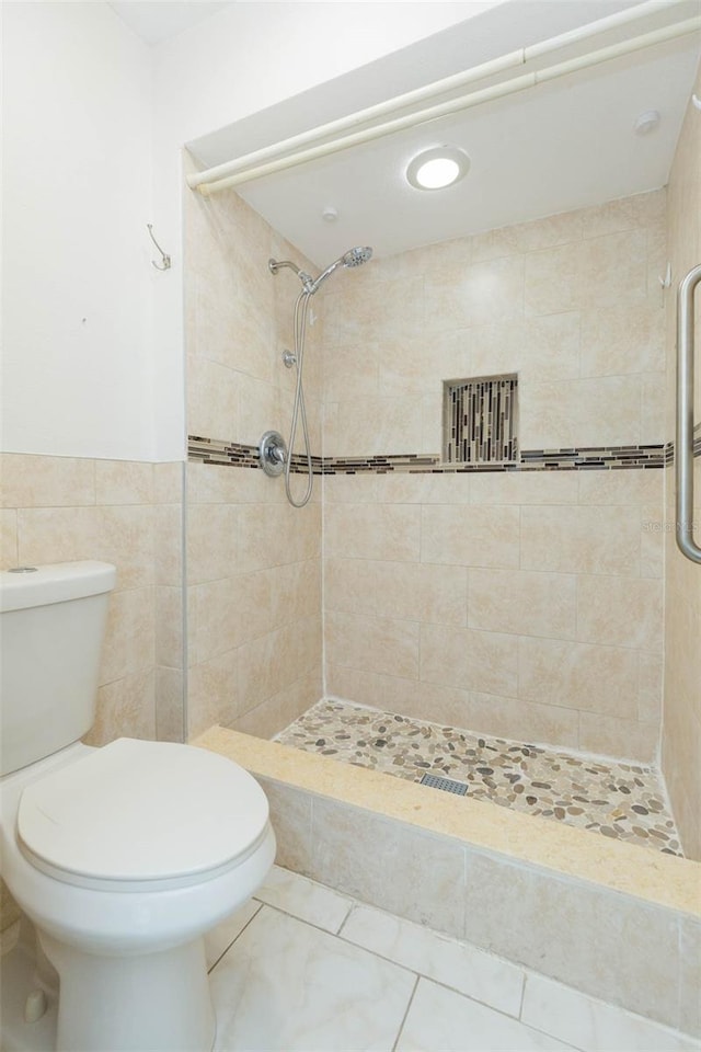 2211 Bay Berry Ln, Clearwater, FL 33763 - full bathroom with a stall shower, toilet, tile walls, a wainscoted wall, and tile patterned floors