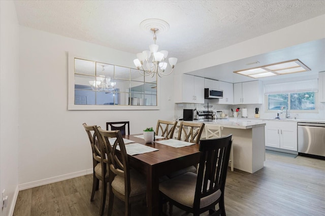 1010 Oakhill St, Seffner, FL 33584 - dining area with a chandelier, light wood-style floors, a textured ceiling, and baseboards