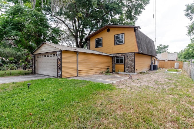 1010 Oakhill St, Seffner, FL 33584 - rear view of property featuring stone siding, central air condition unit, a detached garage, a gambrel roof, and roof with shingles