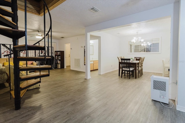 1010 Oakhill St, Seffner, FL 33584 - living area featuring stairway, wood finished floors, heating unit, baseboards, and a textured ceiling