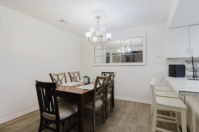 1010 Oakhill St, Seffner, FL 33584 - dining space with a chandelier, light wood-style flooring, baseboards, and a textured ceiling