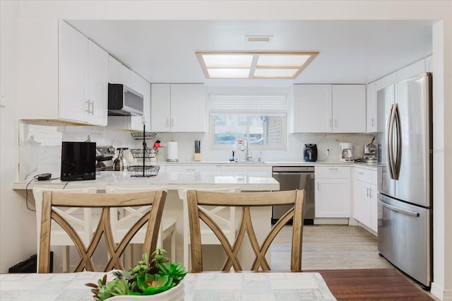 1010 Oakhill St, Seffner, FL 33584 - kitchen with appliances with stainless steel finishes, a sink, decorative backsplash, and white cabinets