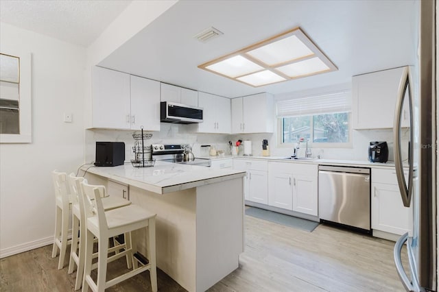 1010 Oakhill St, Seffner, FL 33584 - kitchen featuring stainless steel appliances, a peninsula, a sink, and white cabinets