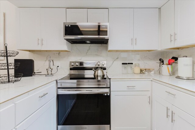 1010 Oakhill St, Seffner, FL 33584 - kitchen with appliances with stainless steel finishes, white cabinets, decorative backsplash, and light stone countertops
