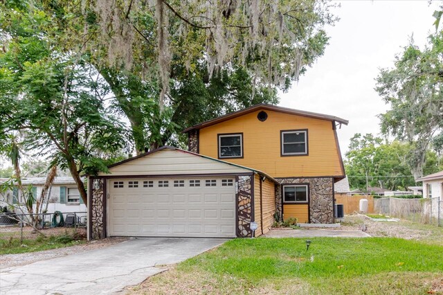 1010 Oakhill St, Seffner, FL 33584 - view of front facade with stone siding, driveway, a garage, and central air condition unit