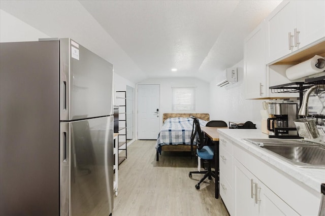 1010 Oakhill St, Seffner, FL 33584 - kitchen with freestanding refrigerator, vaulted ceiling, a wall mounted air conditioner, light wood-type flooring, and light countertops