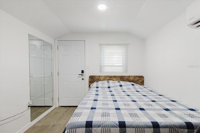 1010 Oakhill St, Seffner, FL 33584 - bedroom with vaulted ceiling, wood finished floors, and a wall unit AC
