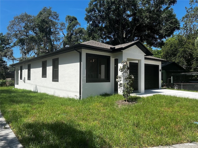 4241 E Palifox St, Tampa, FL 33610 - view of home's exterior featuring stucco siding, a garage, concrete driveway, and a yard