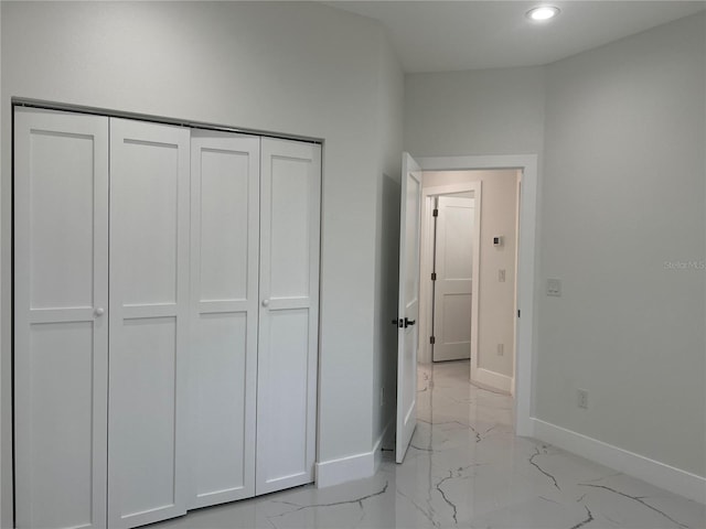 4241 E Palifox St, Tampa, FL 33610 - unfurnished bedroom featuring light marble finish floors, a closet, and recessed lighting