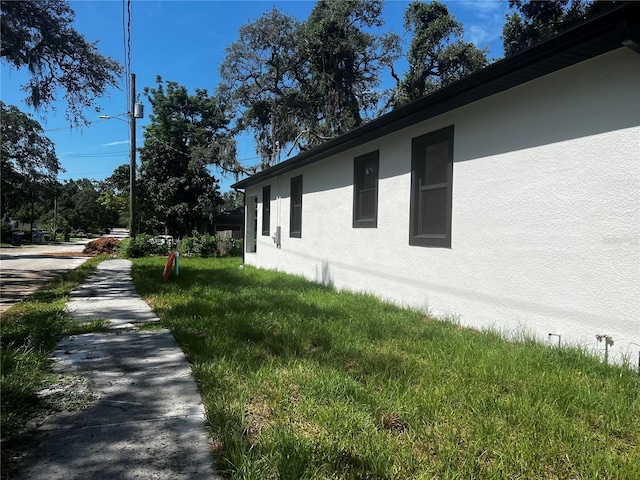 4241 E Palifox St, Tampa, FL 33610 - view of property exterior with stucco siding and a yard