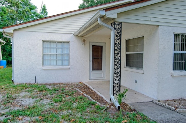 1262 Jeffords St, Clearwater, FL 33756 - view of exterior entry with stucco siding and a patio area
