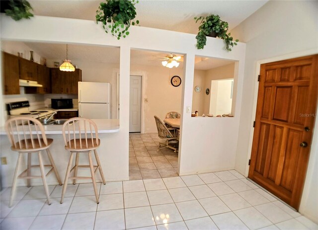 1262 Jeffords St, Clearwater, FL 33756 - kitchen featuring freestanding refrigerator, electric range, under cabinet range hood, a breakfast bar, and ceiling fan