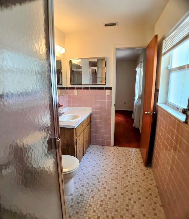1262 Jeffords St, Clearwater, FL 33756 - bathroom with tile walls, vanity, toilet, and an enclosed shower