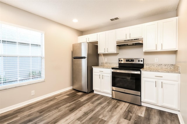 2216 Heathwood Cir, Orlando, FL 32828 - kitchen with appliances with stainless steel finishes, under cabinet range hood, wood finished floors, plenty of natural light, and recessed lighting